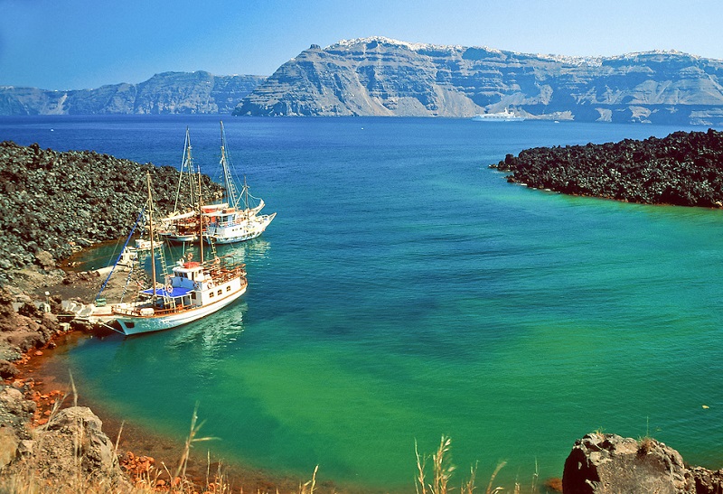 Boats at Nea Kameni volcano, Aegean Sea, near Fira, Santorini Island, Greece.